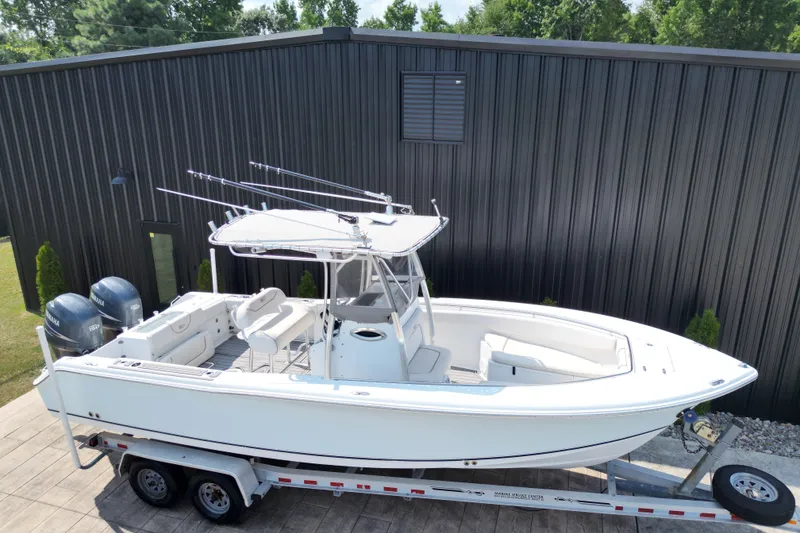 Slide: The Image of 2008 Sea Hunt Triton 260 boat on trailer, parked near a black building. - 21