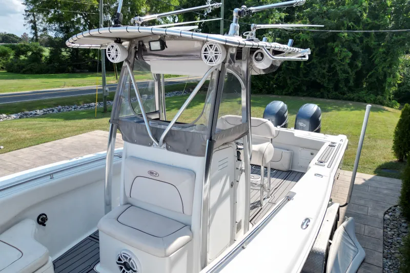 Slide: The Image of 2008 Sea Hunt Triton 260 boat with dual engines and spacious deck, parked outdoors. - 12
