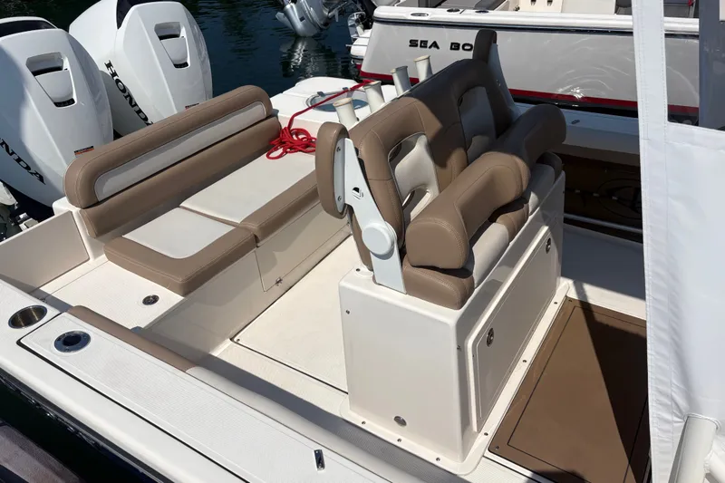 Slide: The Image of 2024 Sea Born LX24 Center Console boat interior with tan seating and Honda engines. - 13