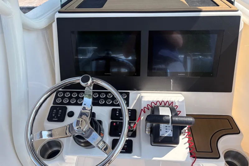 Slide: The Image of 2024 Sea Born LX24 Center Console dashboard with dual Garmin displays and steering wheel. - 9