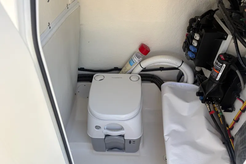 Slide: The Image of 2024 Sea Born LX24 Center Console boat interior with portable toilet and equipment. - 5