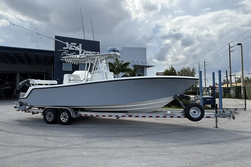 The Image of 2019 SeaVee 290B boat on trailer, parked outside a dealership under cloudy skies. - 0