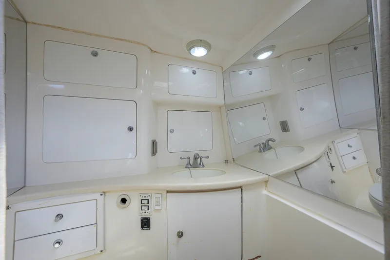 Slide: The Image of Bathroom interior of a 2009 Intrepid 370 boat with white cabinetry and sink. - 23