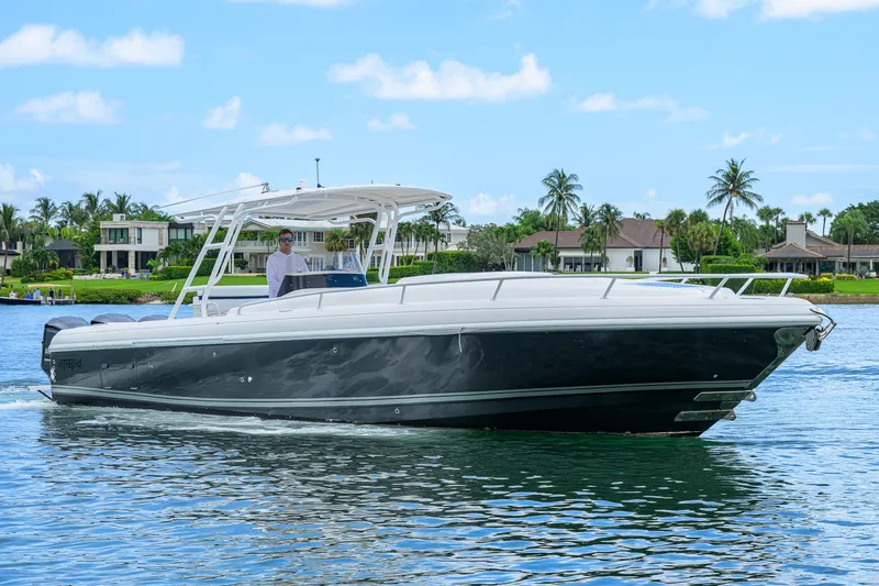 Slide: The Image of 2009 Intrepid 370 boat cruising on a sunny day near waterfront homes. - 1