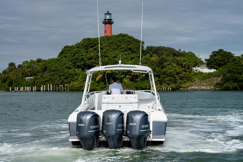 Slide: The Image of A 2009 Intrepid 370 boat on the water, with a lighthouse in the background. - 1