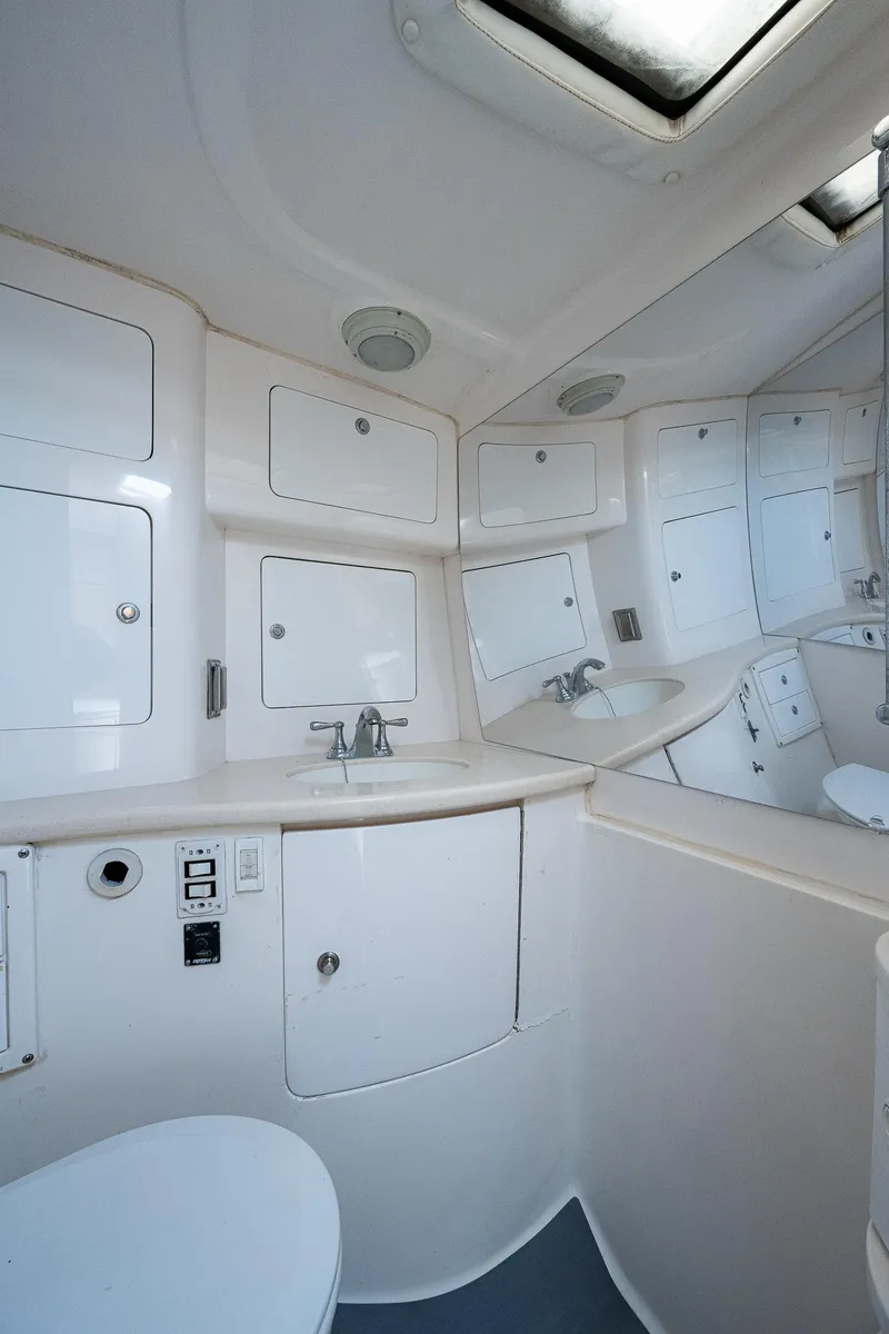 Slide: The Image of The image shows a clean, modern boat bathroom with white cabinets and a sink. - 4
