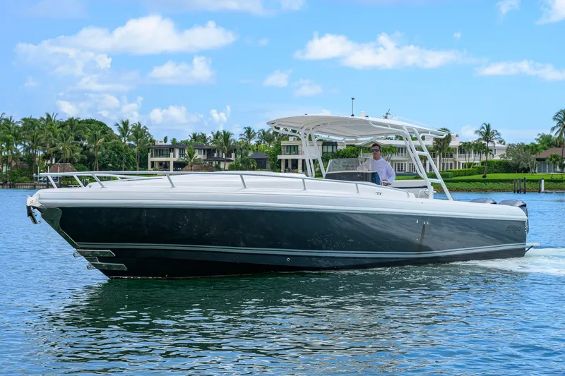 Slide: The Image of 2009 Intrepid 370 boat cruising on a sunny day, with waterfront homes in the background. - 2