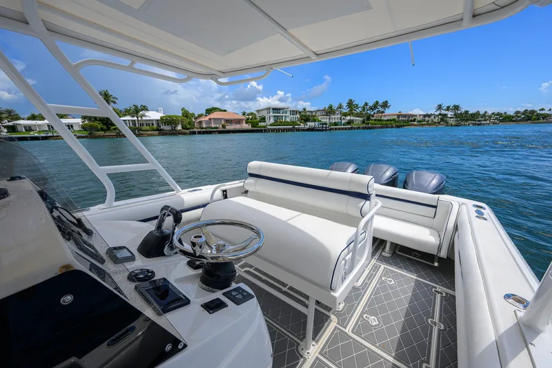 Slide: The Image of 2009 Intrepid 370 boat interior with steering wheel, seating, and scenic waterfront view. - 13
