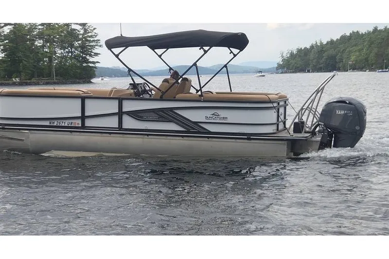 Slide: The Image of 2025 SunCatcher 324 Rc Fusion pontoon boat cruising on a scenic lake. - 1