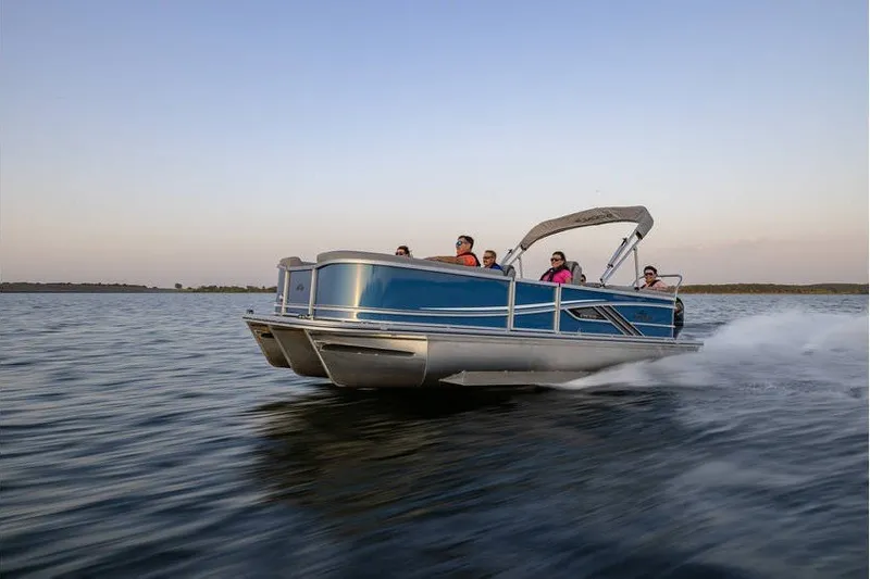 Slide: The Image of 2025 SunCatcher 324 Rc Fusion pontoon boat cruising on a serene lake at sunset. - 10