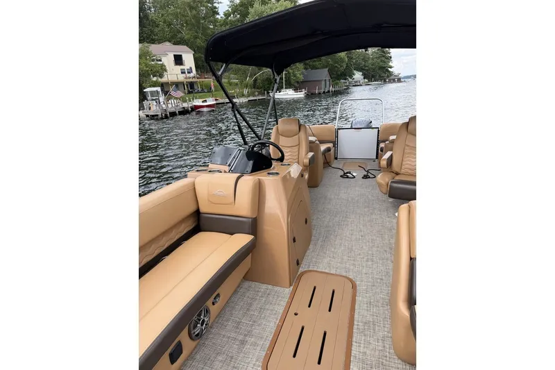 Slide: The Image of 2025 SunCatcher 324 Rc Fusion pontoon boat with tan seating, on a scenic lake. - 7