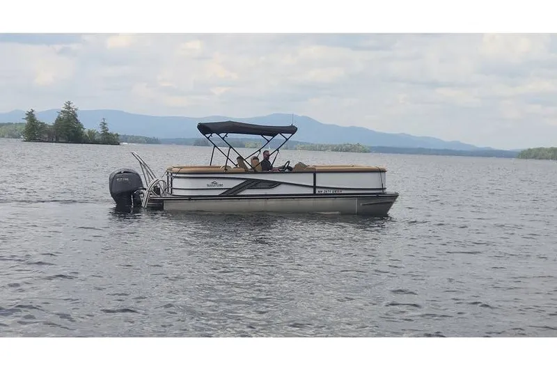 The Image of 2025 SunCatcher 324 Rc Fusion pontoon boat cruising on a scenic lake. - 0