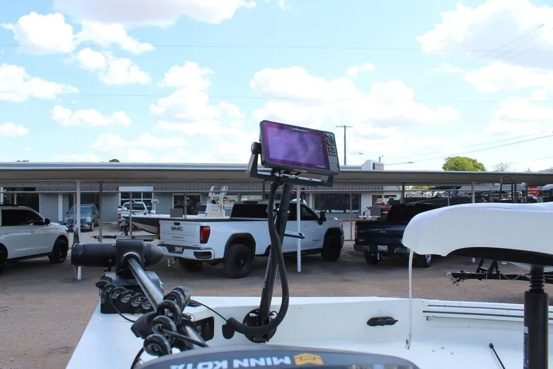 Slide: The Image of 2025 Excel 220 Bay Pro Elite boat with advanced navigation system, parked near trucks. - 8