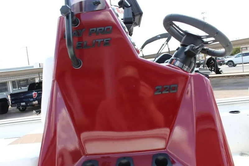Slide: The Image of 2025 Excel 220 Bay Pro Elite boat console with steering wheel and controls. - 14