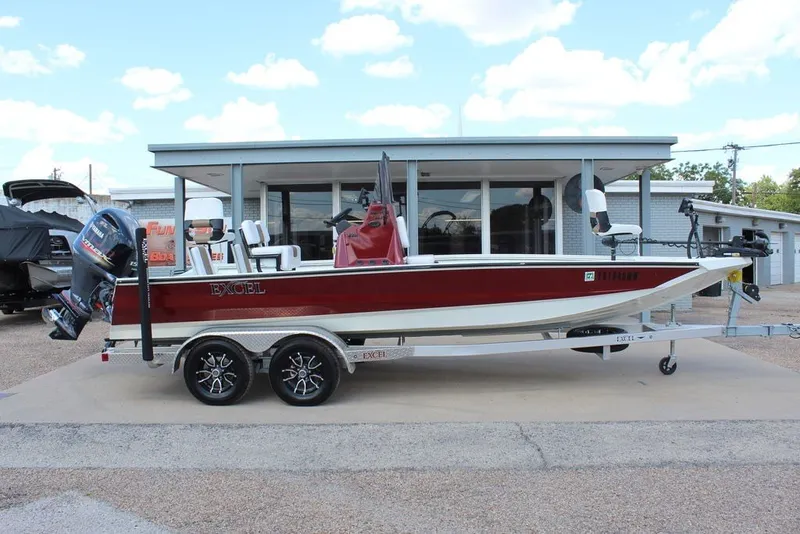 Slide: The Image of 2025 Excel 220 Bay Pro Elite boat on trailer, parked outside a building. - 4