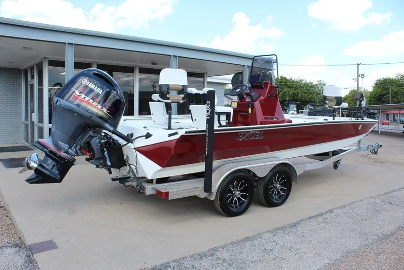 Slide: The Image of 2025 Excel 220 Bay Pro Elite boat with Yamaha motor on trailer, parked outside. - 3