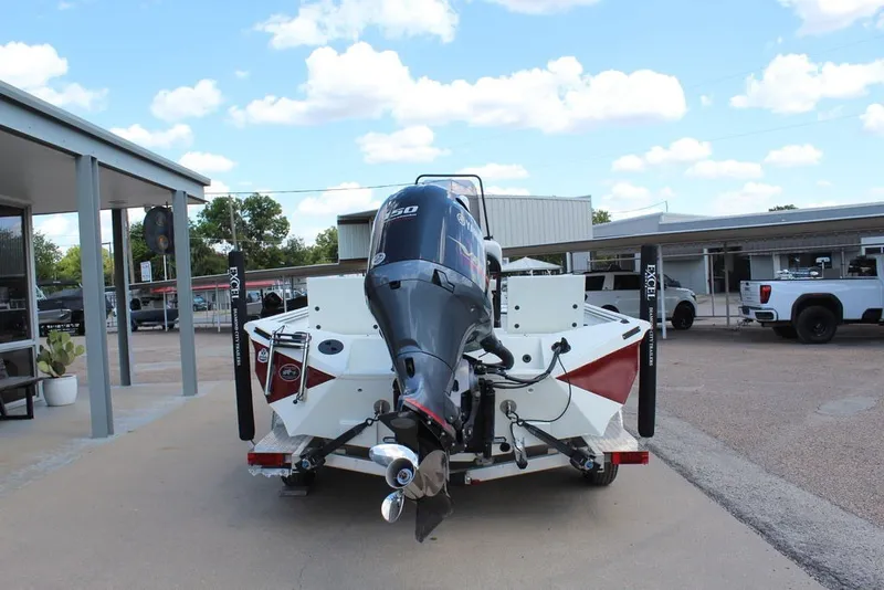 Slide: The Image of 2025 Excel 220 Bay Pro Elite boat with powerful outboard motor, parked outdoors. - 2