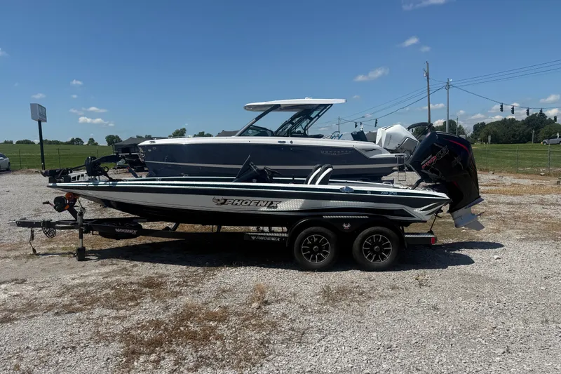 The Image of 2027 Phoenix 720 ZXL boat on trailer, parked outdoors under clear blue sky. - 1