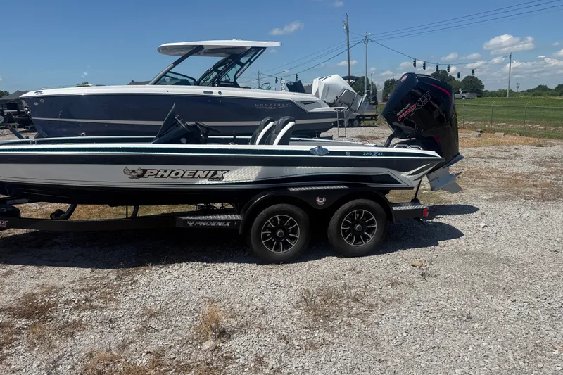 Slide: The Image of 2027 Phoenix 720 ZXL boat on trailer, parked outdoors under clear sky. - 2