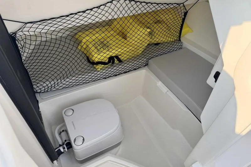 Slide: The Image of Interior of 2022 Sea Ray SDX 250 boat with portable toilet and storage net. - 16