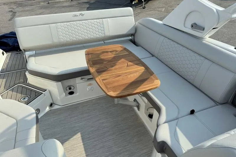 Slide: The Image of 2022 Sea Ray SDX 250 boat interior with white seating and wooden table. - 15