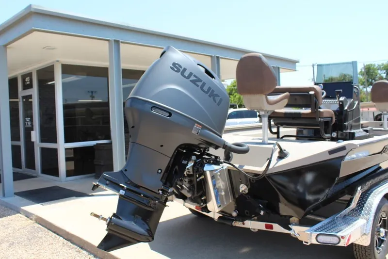 Slide: The Image of 2027 Excel 220 Bay Pro Elite boat with Suzuki outboard motor, parked near a building. - 6