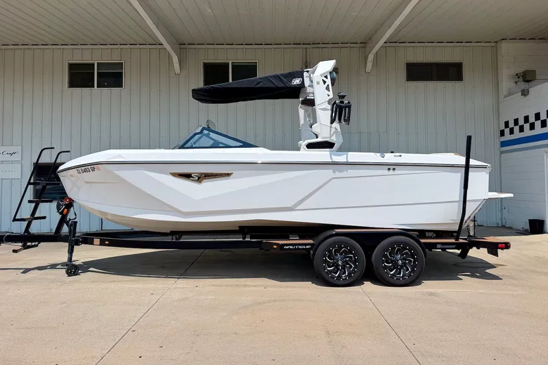 The Image of 2023 Nautique Super Air Nautique S23 boat on trailer, parked outdoors. - 1