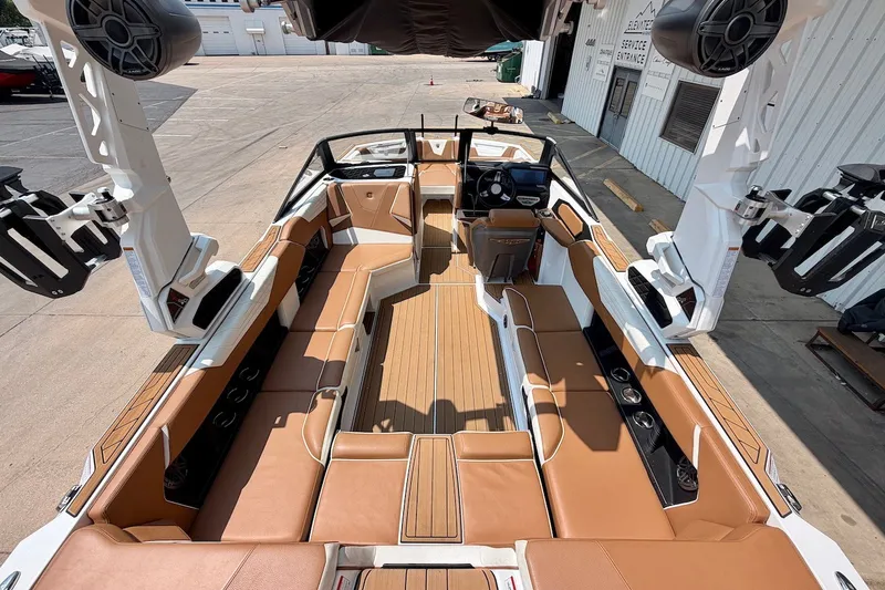 Slide: The Image of 2023 Nautique Super Air Nautique S23 interior with tan seating and advanced audio system. - 12