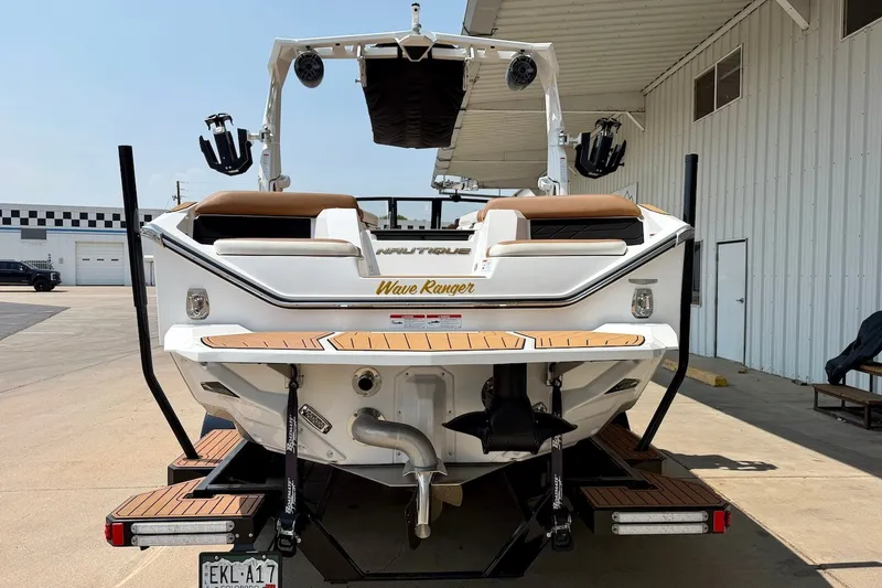 Slide: The Image of 2023 Nautique Super Air Nautique S23 boat, rear view, parked at a marina. - 5