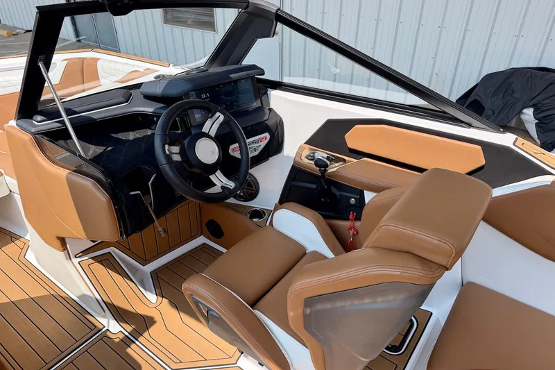 Slide: The Image of 2023 Nautique Super Air Nautique S23 interior with brown leather seats and modern dashboard. - 13