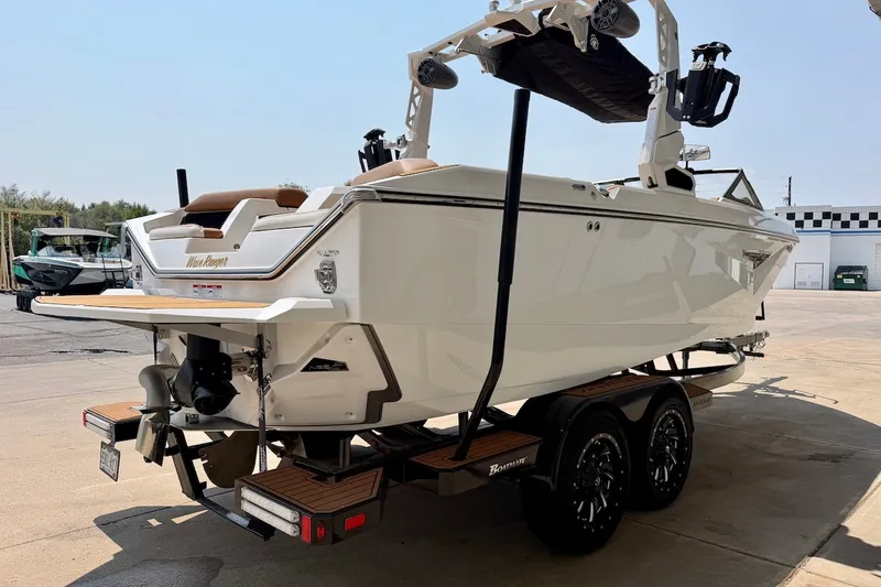 Slide: The Image of 2023 Nautique Super Air Nautique S23 boat on trailer, rear view in outdoor setting. - 7