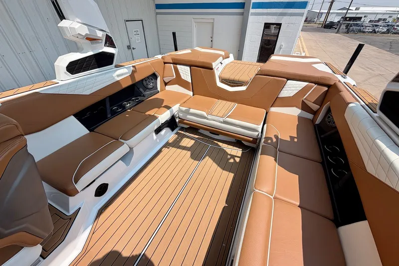Slide: The Image of 2023 Nautique Super Air Nautique S23 interior with tan and white seating, sleek design. - 22