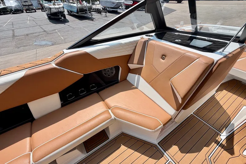 Slide: The Image of 2023 Nautique Super Air Nautique S23 interior with tan and white seating. - 21