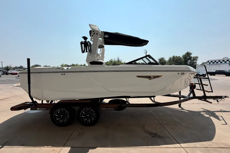 Slide: The Image of 2023 Nautique Super Air Nautique S23 boat on trailer, side view in outdoor setting. - 8