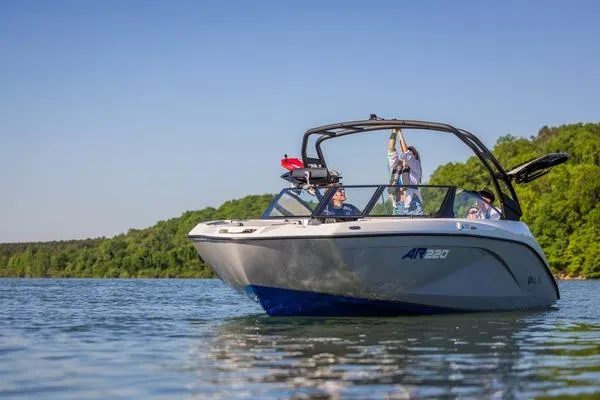 The Image of 2026 Yamaha Boats AR220 on a serene lake with lush green shoreline. - 1