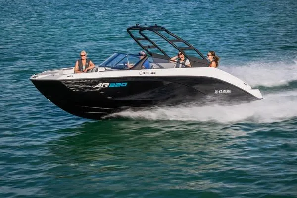 The Image of 2026 Yamaha Boats AR220 speeding on water with passengers enjoying the ride. - 2