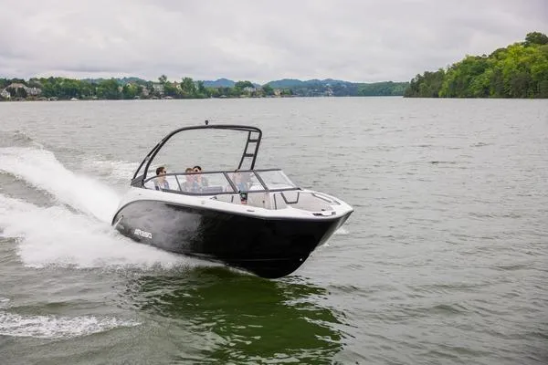 Slide: The Image of 2026 Yamaha Boats AR250 cruising on a scenic lake with lush green shoreline. - 1