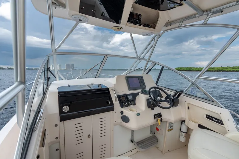 Slide: The Image of 2006 Grady-White Gulfstream 232 boat cockpit with steering wheel and navigation equipment. - 21