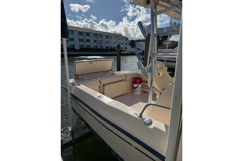 Slide: The Image of 2006 Grady-White Gulfstream 232 boat docked, featuring spacious seating and fishing rod holders. - 2