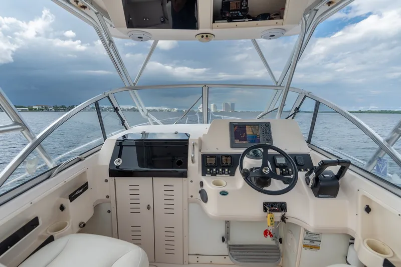 Slide: The Image of 2006 Grady-White Gulfstream 232 boat cockpit with steering wheel and navigation equipment. - 22