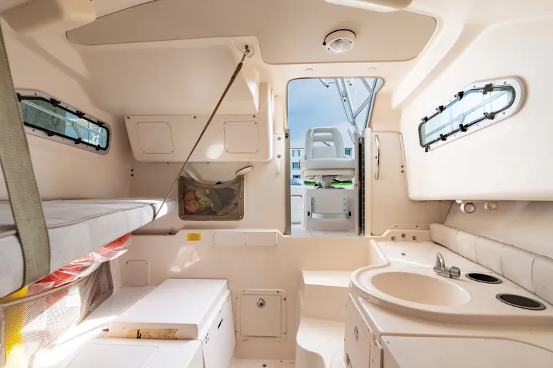 Slide: The Image of Interior of 2006 Grady-White Gulfstream 232 boat, featuring seating and compact kitchenette. - 27