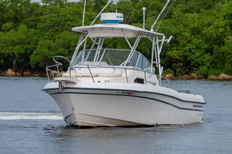 Slide: The Image of 2006 Grady-White Gulfstream 232 boat cruising on calm water near lush greenery. - 15