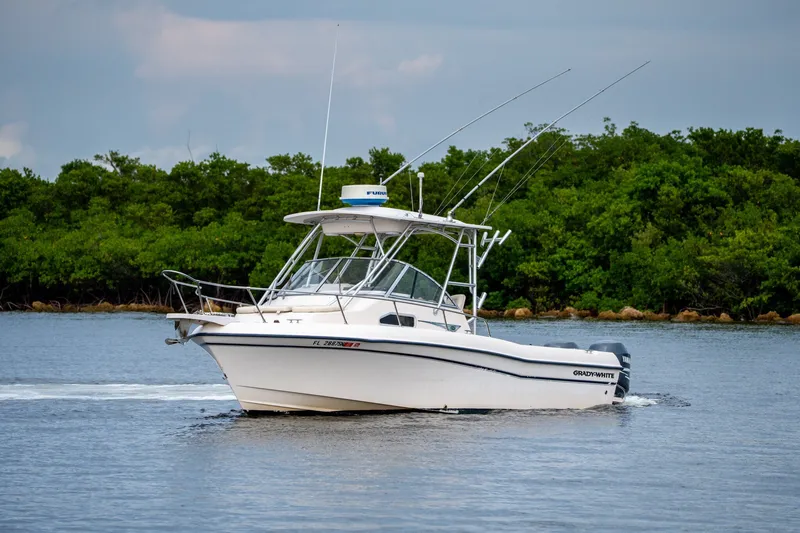Slide: The Image of 2006 Grady-White Gulfstream 232 boat cruising on calm water near lush greenery. - 13