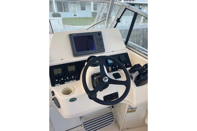 Slide: The Image of 2006 Grady-White Gulfstream 232 helm with steering wheel and navigation controls. - 7