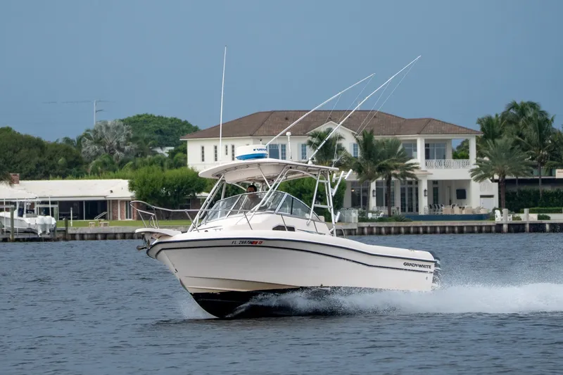 Slide: The Image of 2006 Grady-White Gulfstream 232 boat cruising on water near luxury waterfront homes. - 28