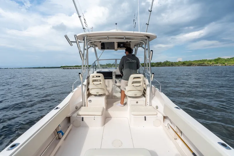 Slide: The Image of 2006 Grady-White Gulfstream 232 boat on open water, with person steering under cloudy sky. - 18