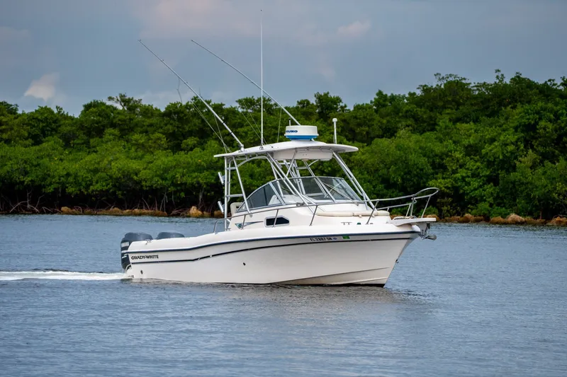 Slide: The Image of 2006 Grady-White Gulfstream 232 boat cruising on a calm lake with lush greenery. - 29