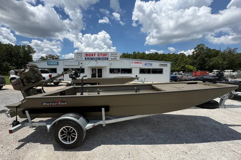 The Image of 2026 Gator Tail 1748 GATOR SERES boat on trailer at dealership under cloudy sky. - 1