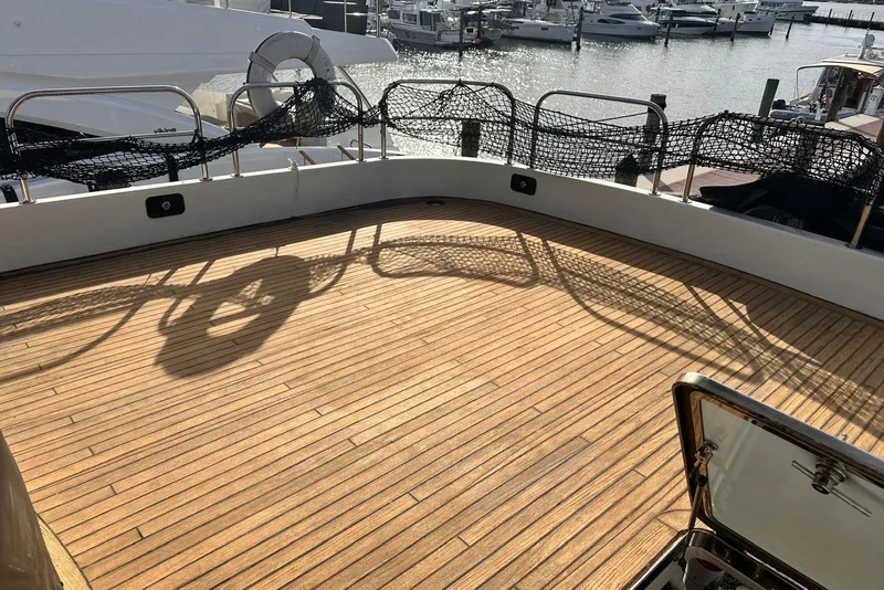 Slide: The Image of Deck of 1999 Azimut 85 Ultimate yacht with wooden flooring and marina view. - 100
