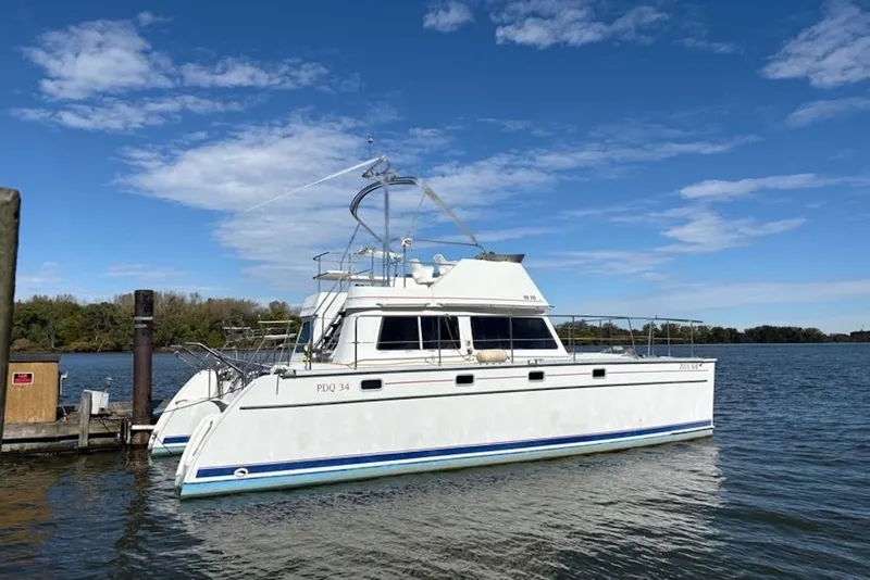 The Image of 2003 PDQ 34 Power Catamaran docked on a sunny day with blue sky. - 0